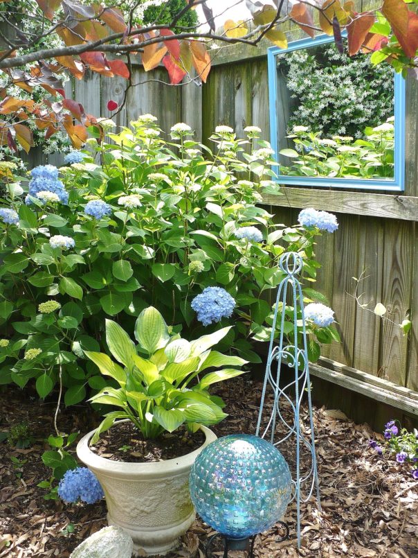 blue mirror in the garden hanging on the fence