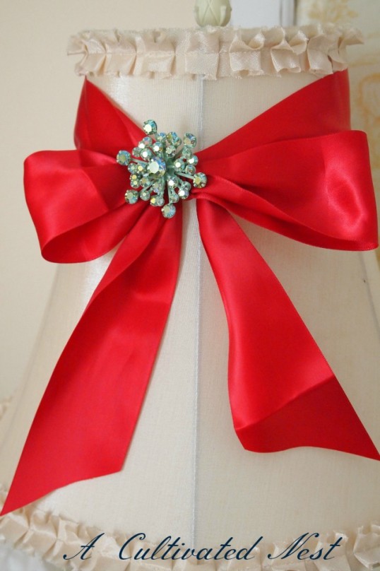 lampshade with red ribbon bow and vintage jewelry