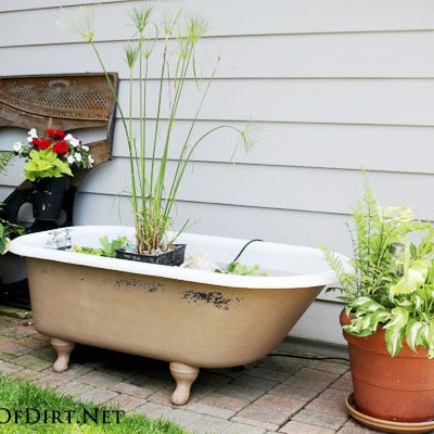 Making a Garden Pond in a Bathtub- Using an old bathtub as a container garden is easy, beautiful, and useful, too. They can hold a lot of plants and enhance your design! | upcycle bathtub, recycle bathtub, ways to use a vintage bathtub, #gardeningTips #gardenDIY #containerGarden #gardeningDIY #ACultivatedNest