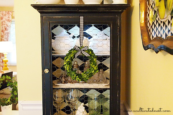 black china cabinet with boxwood wreath
