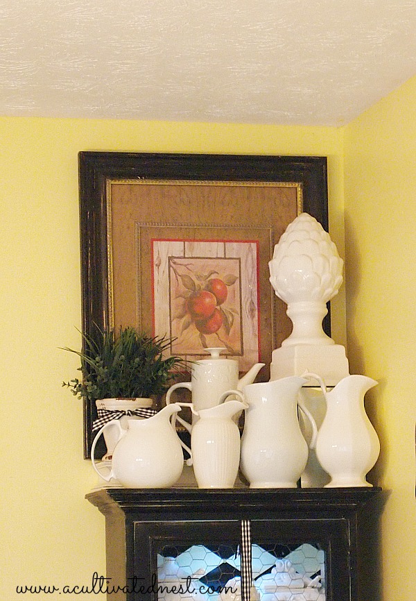a collection of white pottery on a black cabinet