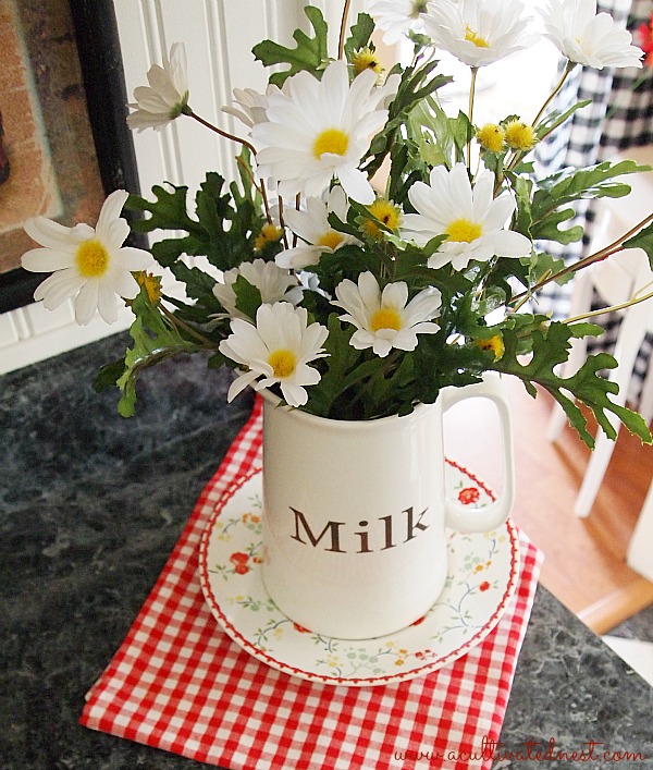 milk jug filled with daisies