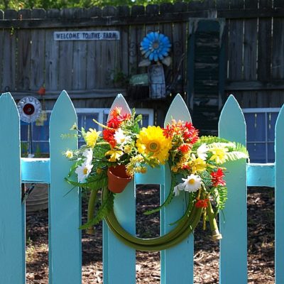 blue garden gate and garden hose wreath