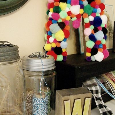 craft letter covered with pom poms