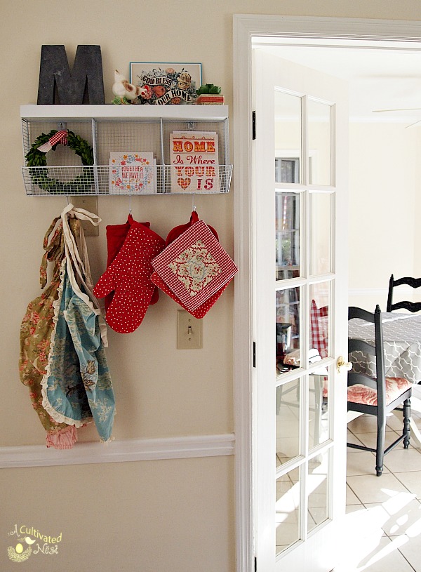 Cute kitchen shelf with hooks and cubbies provides needed storage and display space in a small kitchen