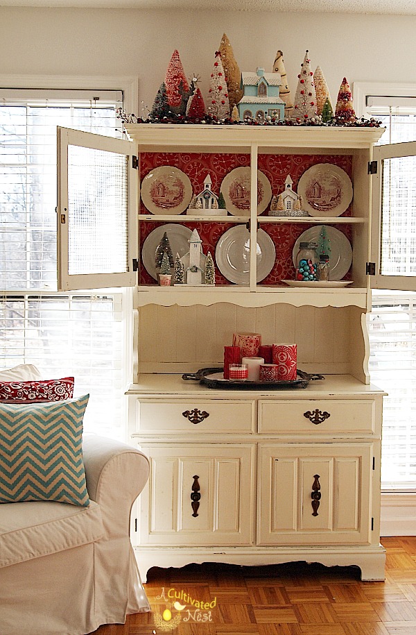 Pretty Christmas China cabinet decorating ideas. Bottle brush trees, glitter houses, red transferware and red and aqua colors. So cute!