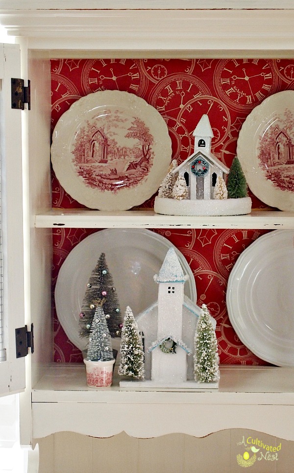 Cute Christmas china cabinet decorations!  Bottle brush trees, red transferware and glitter houses!