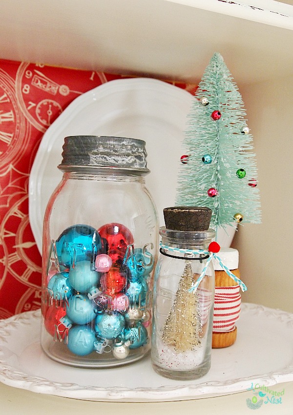 Pretty Christmas china cabinet! Vintage mason jar filled with Shiny Brites and other Christmas ornaments - easy Christmas decorating idea!