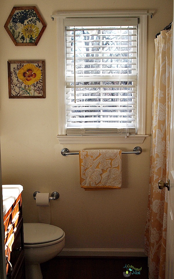 Small bathroom decorated with yellow decor items & shower curtains