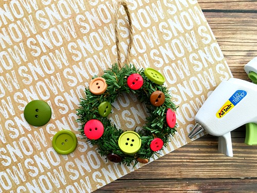 Want to make a fun DIY Christmas tree ornament with your kids? Then you have to put together this cute mini Mason jar lid ring wreath ornament! | Christmas craft, holiday DIY, mini wreath ornament