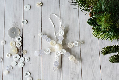 Popsicle Stick Button Snowflake- This homemade Christmas tree ornament is so fun to make, and easy to customize! This year, add this cute DIY popsicle stick button snowflake to your tree! | diy Christmas ornament, Christmas craft, homemade Christmas ornament ideas