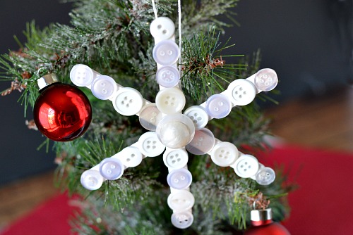 Popsicle Stick Button Sneeuwvlok - Dit zelfgemaakte kerstboomornament is zo leuk om te maken en gemakkelijk aan te passen!  Voeg dit jaar deze schattige DIY-ijslollyknop-sneeuwvlok toe aan je boom!  |  diy kerstornament, kerstknutselen, zelfgemaakte kerstornamentideeën