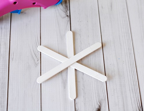 Popsicle Stick Button Snowflake- This homemade Christmas tree ornament is so fun to make, and easy to customize! This year, add this cute DIY popsicle stick button snowflake to your tree! | diy Christmas ornament, Christmas craft, homemade Christmas ornament ideas