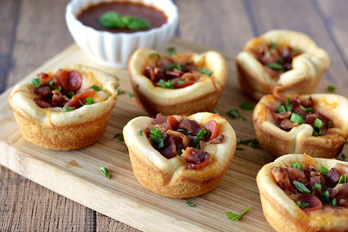 Mini Pizza Muffin Tin Appetizers- These mini pizza muffin tin appetizers are quick and easy to make, but have the flavor of a full-sized pizza! They'd make a good after-school snack, too! | New Year's Eve appetizer, New Year's recipe, party food, after-school snack, finger food, pizza bites, easy recipe