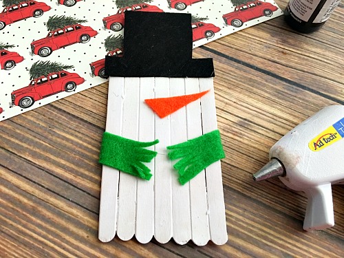 Cute Snowman Popsicle Stick Craft- An easy way to keep the kids busy this holiday season is with a fun holiday activity! You only need a couple inexpensive supplies to make this snowman popsicle stick craft! | kids craft, kids activity, winter craft, winter activity, craft sticks, easy craft