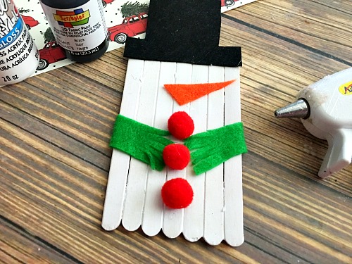 Cute Snowman Popsicle Stick Craft- An easy way to keep the kids busy this holiday season is with a fun holiday activity! You only need a couple inexpensive supplies to make this snowman popsicle stick craft! | kids craft, kids activity, winter craft, winter activity, craft sticks, easy craft