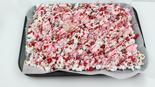 Valentine's Day Chocolate Drizzled Popcorn- This Valentine's Day chocolate drizzled popcorn is a quick and easy no-bake Valentine's treat! It'd also make a great food gift! | dessert, snack, homemade, chocolate, candy, Valentine's food gift, recipe, pink, red #ValentinesDay #popcorn #recipe #dessert