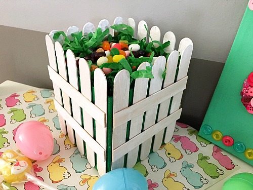 DIY Picket Fence Easter Basket- Why settle for a boring, traditional store-bought Easter basket when you can easily make this DIY picket fence Easter basket that your kids will love! | DIY project, craft idea, Easter gift basket, spring, easy DIY, inexpensive craft