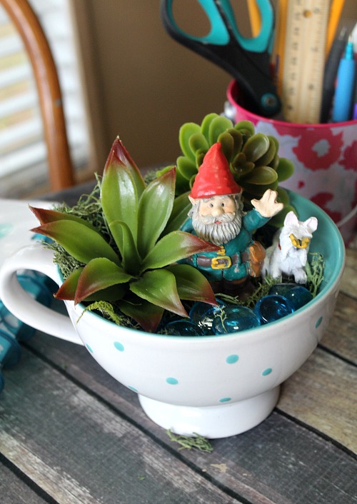 Gnome Tea Cup Fairy Garden- Need a cute decoration for your table or desk? Why not make this adorable DIY gnome tea cup fairy garden! It's easy (and inexpensive)! | DIY decor, gnome garden, cute fairy garden, faux succulents, dollar store, craft, DIY gift idea, homemade gift idea