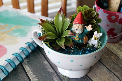 Gnome Tea Cup Fairy Garden- Need a cute decoration for your table or desk? Why not make this adorable DIY gnome tea cup fairy garden! It's easy (and inexpensive)! | DIY decor, gnome garden, cute fairy garden, faux succulents, dollar store, craft, DIY gift idea, homemade gift idea