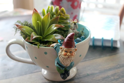 Gnome Tea Cup Fairy Garden- Need a cute decoration for your table or desk? Why not make this adorable DIY gnome tea cup fairy garden! It's easy (and inexpensive)! | DIY decor, gnome garden, cute fairy garden, faux succulents, dollar store, craft, DIY gift idea, homemade gift idea