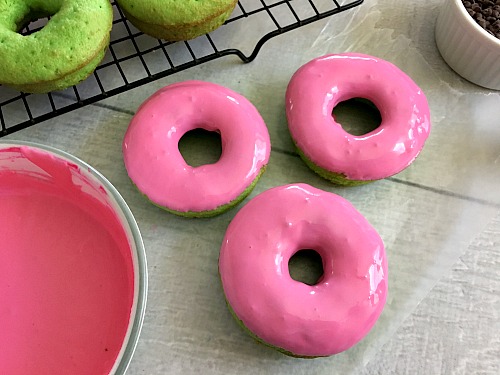 Watermelon Cake Donuts- These watermelon cake donuts are an easy to make dessert that looks so fun and summery! Use boxed cake mix to help put them together quickly! | frosting, pink, green, recipe, dessert, doughnut, baking, make your own donuts, bake donuts at home, summer