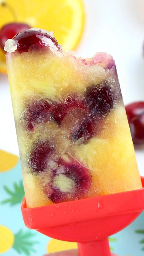 Pineapple, Orange, and Bing Cherry Pops- Beat the summer heat with these delicious homemade pineapple, orange, and Bing cherry pops! These fruit popsicles are made with fresh cherries! | homemade ice pop, popsicle recipe, fresh fruit, healthy, no added sugar, cold dessert treat, summer food