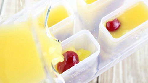 Pineapple, Orange, and Bing Cherry Pops- Beat the summer heat with these delicious homemade pineapple, orange, and Bing cherry pops! These fruit popsicles are made with fresh cherries! | homemade ice pop, popsicle recipe, fresh fruit, healthy, no added sugar, cold dessert treat, summer food