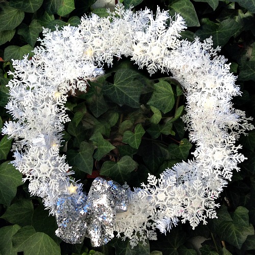 DIY Dollar Store Snowflake Wreath- It doesn't have to cost much to make your home beautiful for winter. Here's how to make a pretty, sparkly snowflake wreath with all dollar store supplies! #diy #craft #wreath #dollarStore