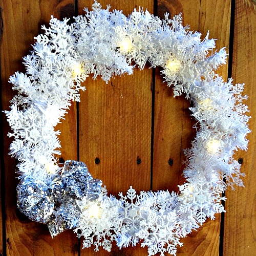 DIY Dollar Store Snowflake Wreath- It doesn't have to cost much to make your home beautiful for winter. Here's how to make a pretty, sparkly snowflake wreath with all dollar store supplies! #diy #craft #wreath #dollarStore