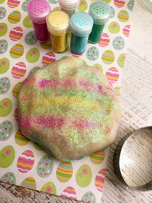 Edible Easter Play Dough- A fun and easy way to make sure your kids don't get into trouble on Easter is by handing them a ball of this homemade edible Easter play dough! It's sparkly, colorful, and 100% safe to eat! It makes a great DIY Easter basket gift, too! | make your own play dough, play dough copycat, homemade play dough, spring craft, #diy #craft #Easter #kidsActivity