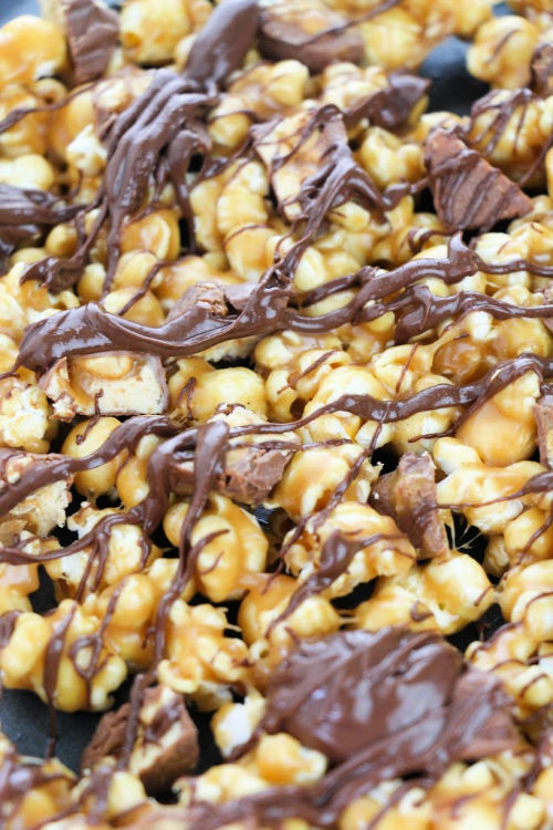 Snickers Chocolate Popcorn- If you are looking for a movie night treat, this delicious homemade Snickers popcorn is what you need! It's easy to make and will win over a crowd! | way to use up leftover Halloween Candy, DIY food gifts, #popcorn #recipe #dessertPopcorn #leftoverHalloweenCandy #ACultivatedNest